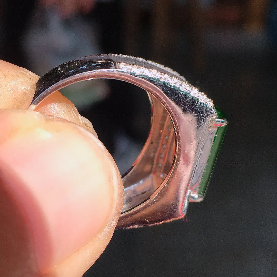 阳绿马鞍戒指，色泽均匀艳丽，玉质细腻，荧光感超
强，饱满圆润，尽显优雅气质，18k
金豪华镶嵌