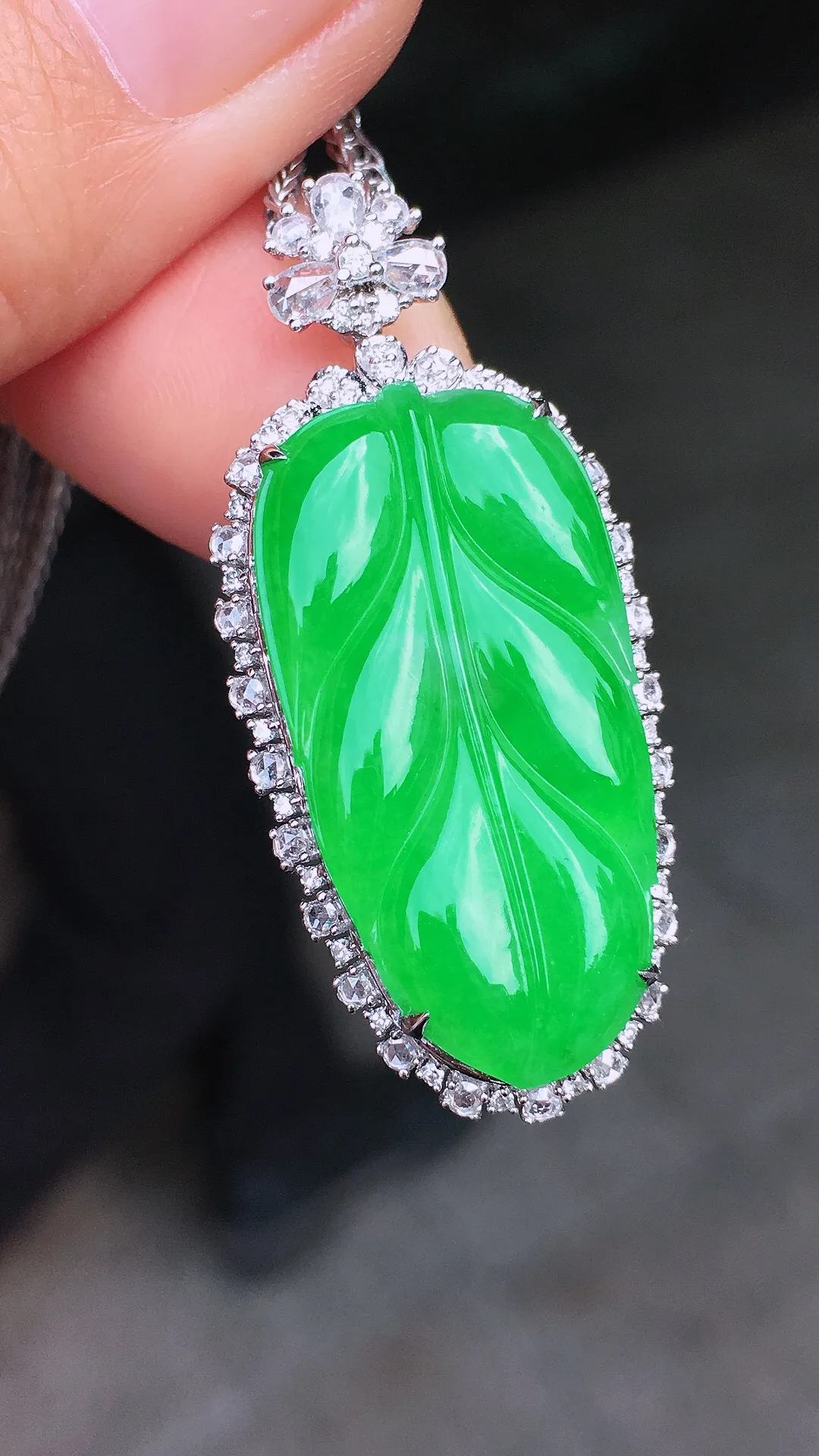 阳绿玉叶吊坠，色泽均匀艳丽，玉质细腻，荧光感超
强，饱满圆润，尽显优雅气质，18k
金豪华镶嵌