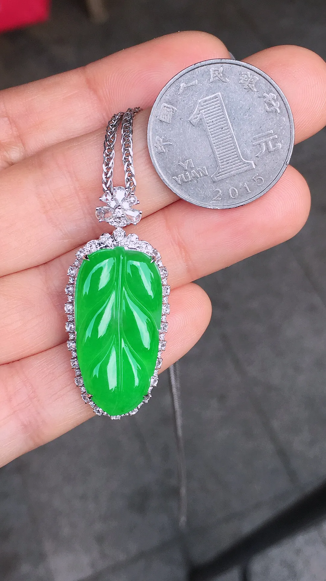 阳绿玉叶吊坠，色泽均匀艳丽，玉质细腻，荧光感超
强，饱满圆润，尽显优雅气质，18k
金豪华镶嵌