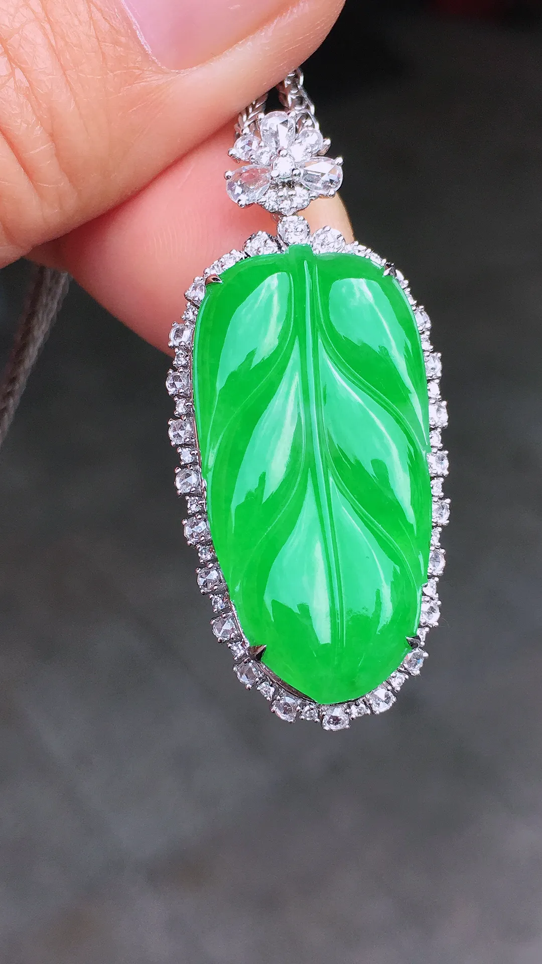 阳绿玉叶吊坠，色泽均匀艳丽，玉质细腻，荧光感超
强，饱满圆润，尽显优雅气质，18k
金豪华镶嵌