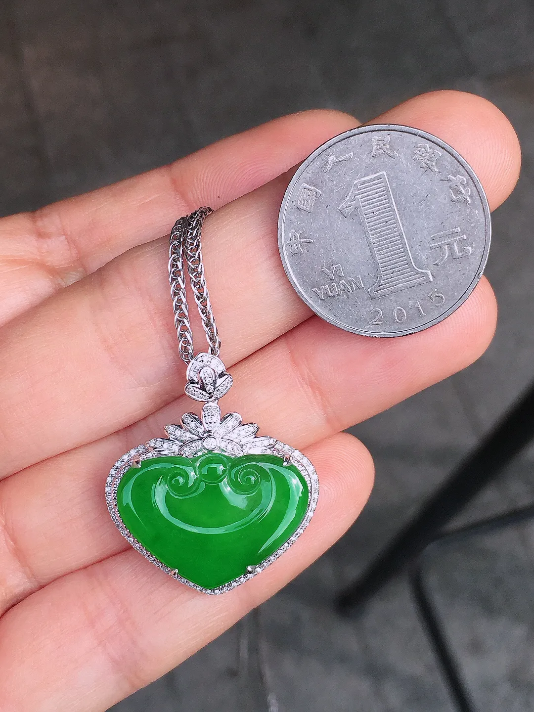 阳绿如意吊坠，色泽均匀艳丽，玉质细腻，荧光感超
强，饱满圆润，尽显优雅气质，18k
金豪华镶嵌