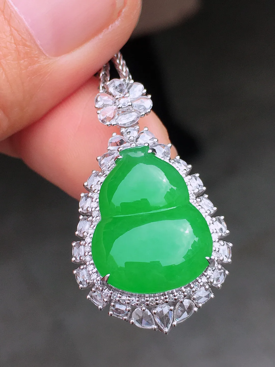 阳绿葫芦吊坠，色泽均匀艳丽，玉质细腻，荧光感超
强，饱满圆润，尽显优雅气质，18k
金豪华镶嵌