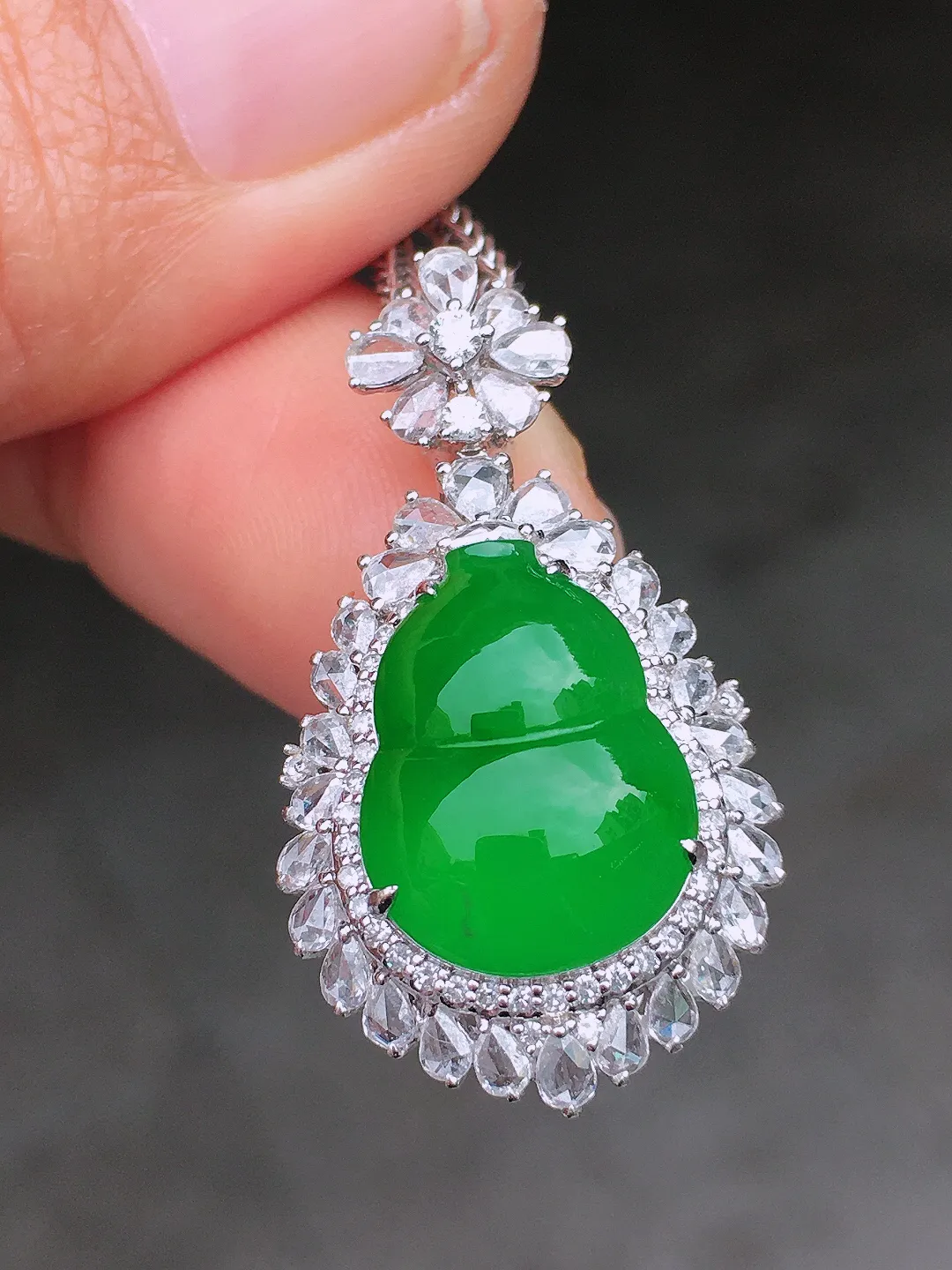 辣绿葫芦吊坠，色泽均匀艳丽，玉质细腻，荧光感超
强，饱满圆润，尽显优雅气质，18k
金豪华镶嵌