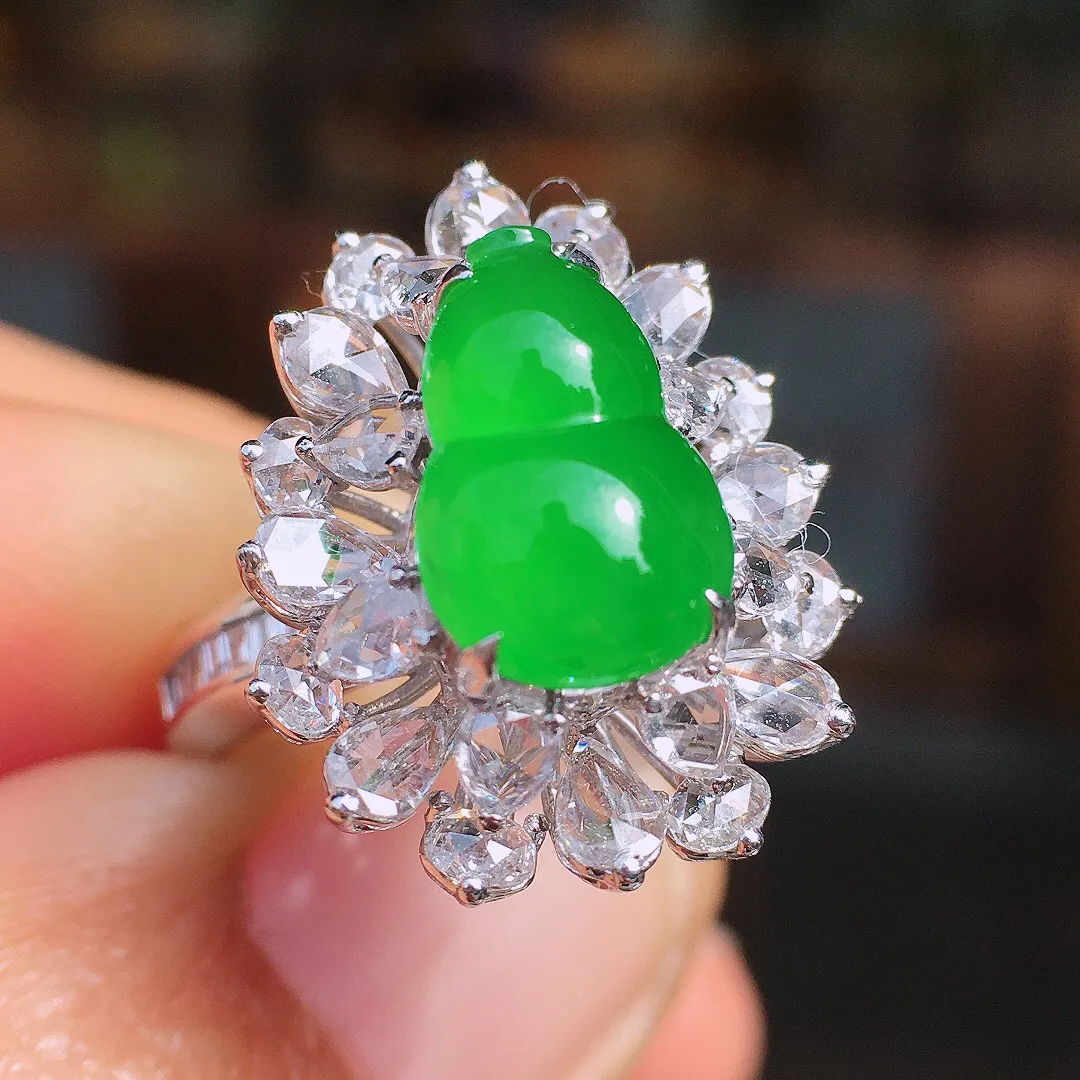 阳绿葫芦戒指，色泽均匀艳丽，玉质细腻，荧光感超
强，饱满圆润，尽显优雅气质，18k
金豪华镶嵌