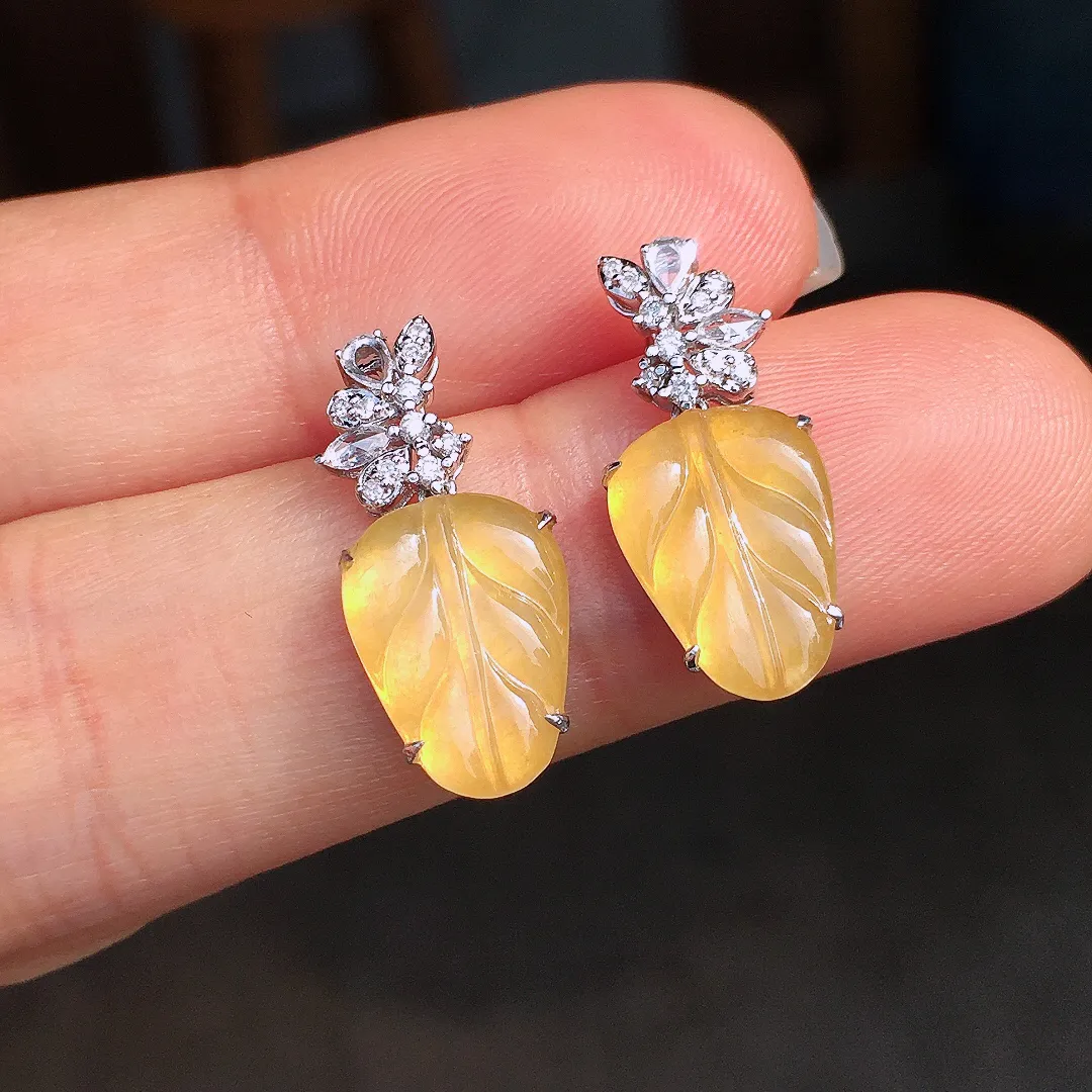 黄翡玉叶耳坠，色泽均匀艳丽，玉质细腻，荧光感超
强，饱满圆润，尽显优雅气质，18k
金豪华镶嵌