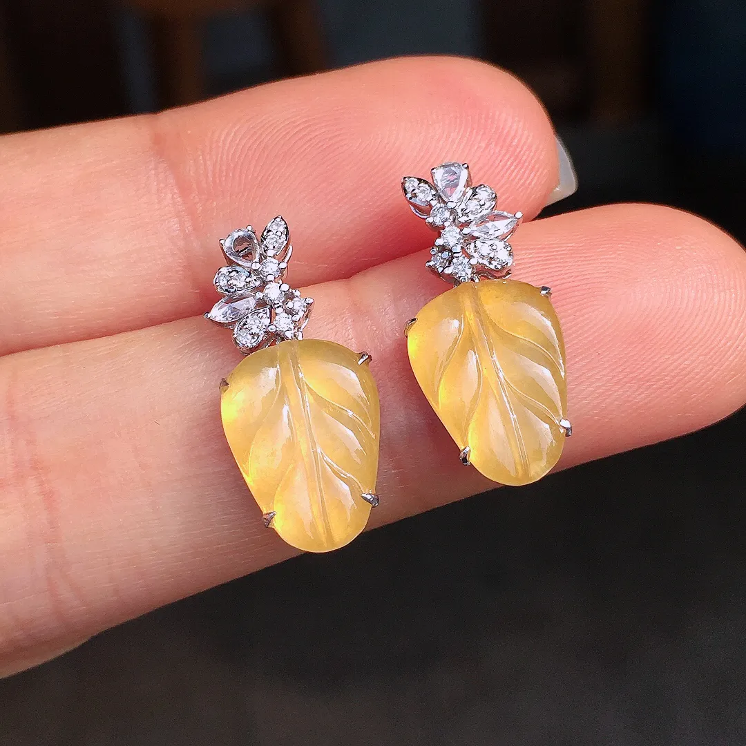 黄翡玉叶耳坠，色泽均匀艳丽，玉质细腻，荧光感超
强，饱满圆润，尽显优雅气质，18k
金豪华镶嵌