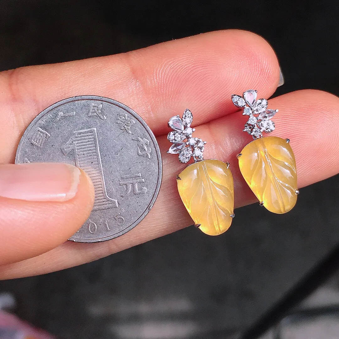 黄翡玉叶耳坠，色泽均匀艳丽，玉质细腻，荧光感超
强，饱满圆润，尽显优雅气质，18k
金豪华镶嵌