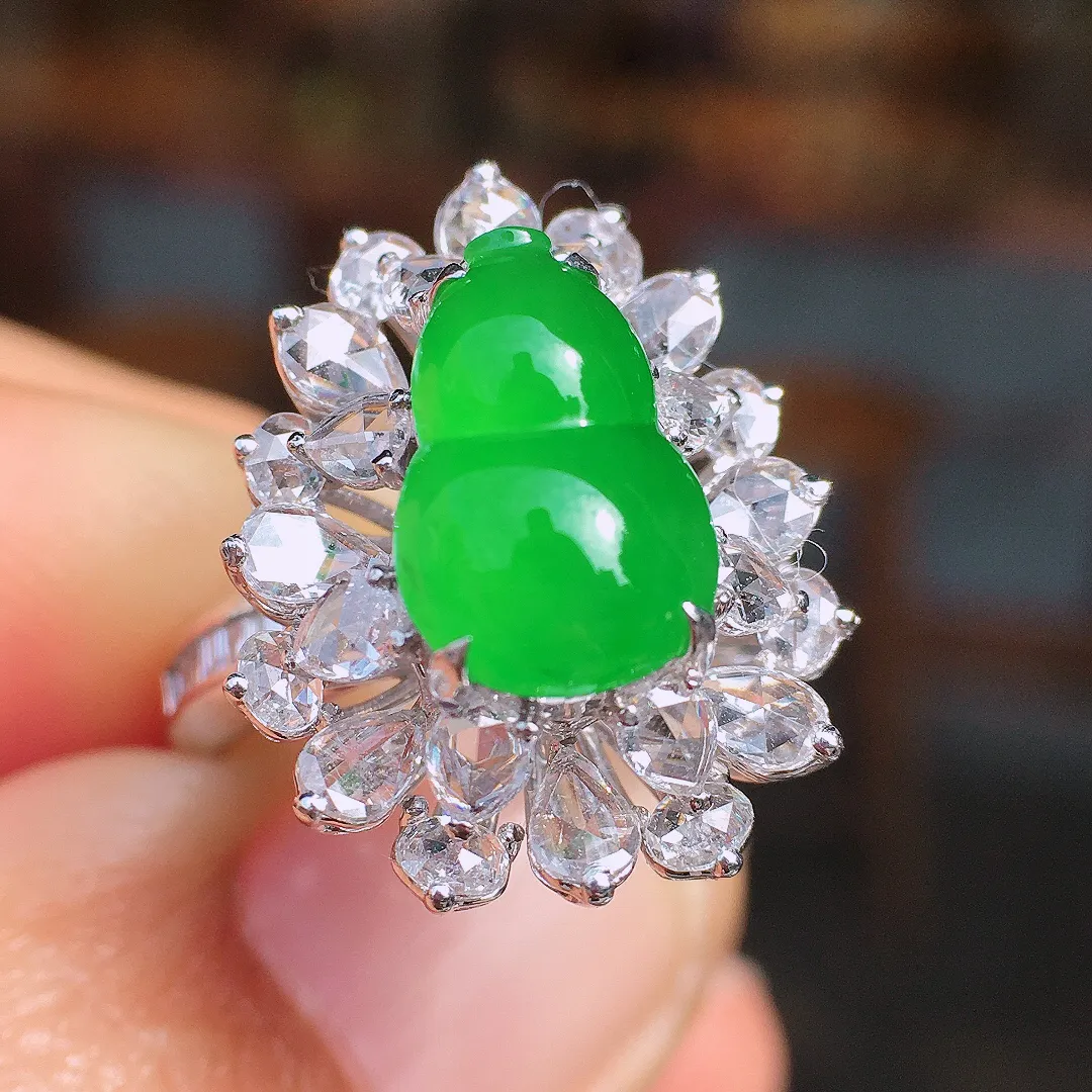 阳绿葫芦戒指，色泽均匀艳丽，玉质细腻，荧光感超
强，饱满圆润，尽显优雅气质，18k
金豪华镶嵌