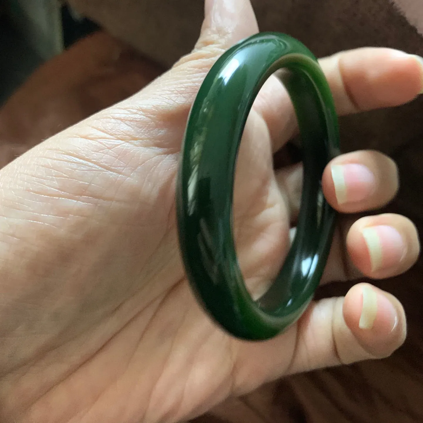 和田玉58.5圈口菠菜绿手镯，镯型古朴典雅。在诗情画意的雨巷相遇，你是我腕间的一抹风情，有你眸有深情.清风荡漾湖间静水，我愿俯身低眉，在烟波涟漪处寻