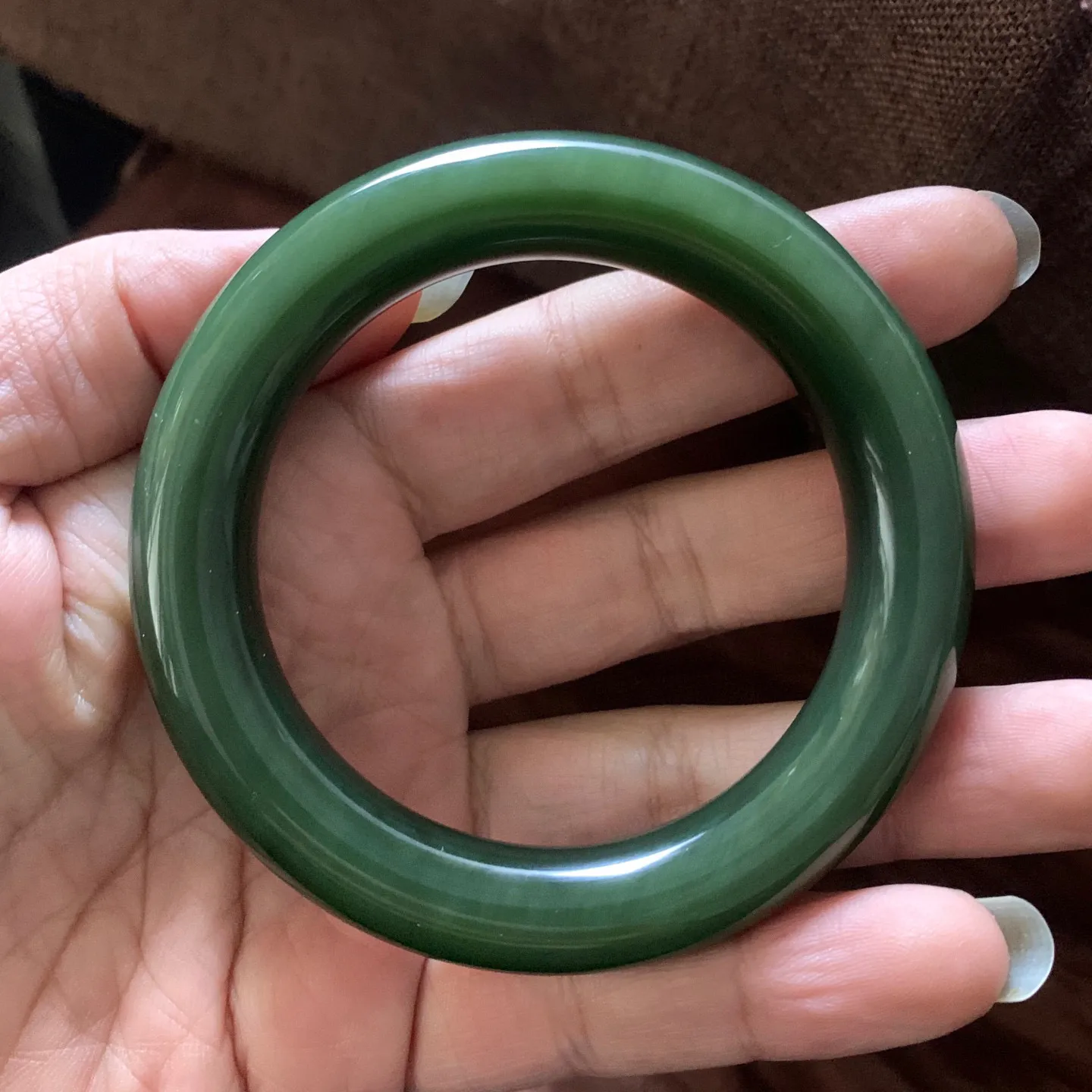 和田玉58圈口菠菜绿圆条手镯，镯型古朴典雅。在诗情画意的雨巷相遇，你是我腕间的一抹风情，有你眸有深情