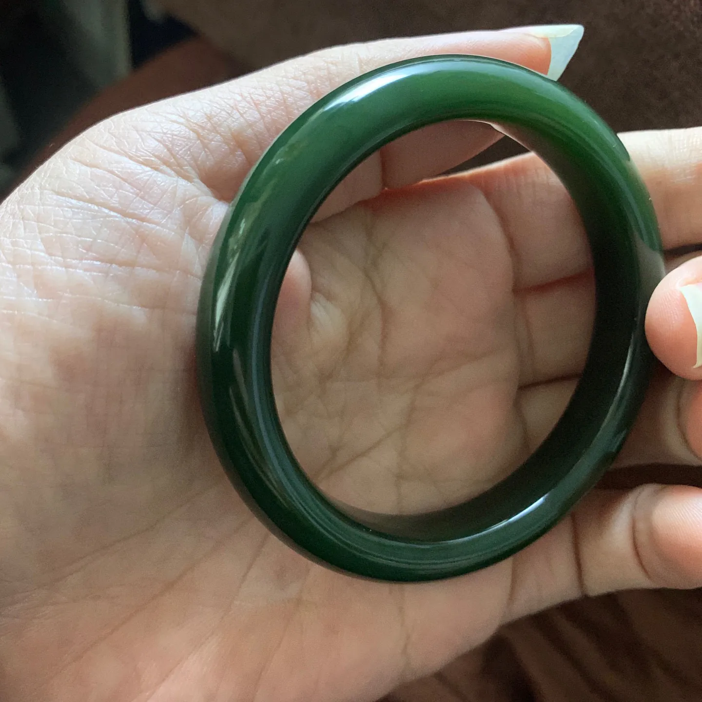 和田玉58.5圈口菠菜绿手镯，镯型古朴典雅。在诗情画意的雨巷相遇，你是我腕间的一抹风情，有你眸有深情.清风荡漾湖间静水，我愿俯身低眉，在烟波涟漪处寻