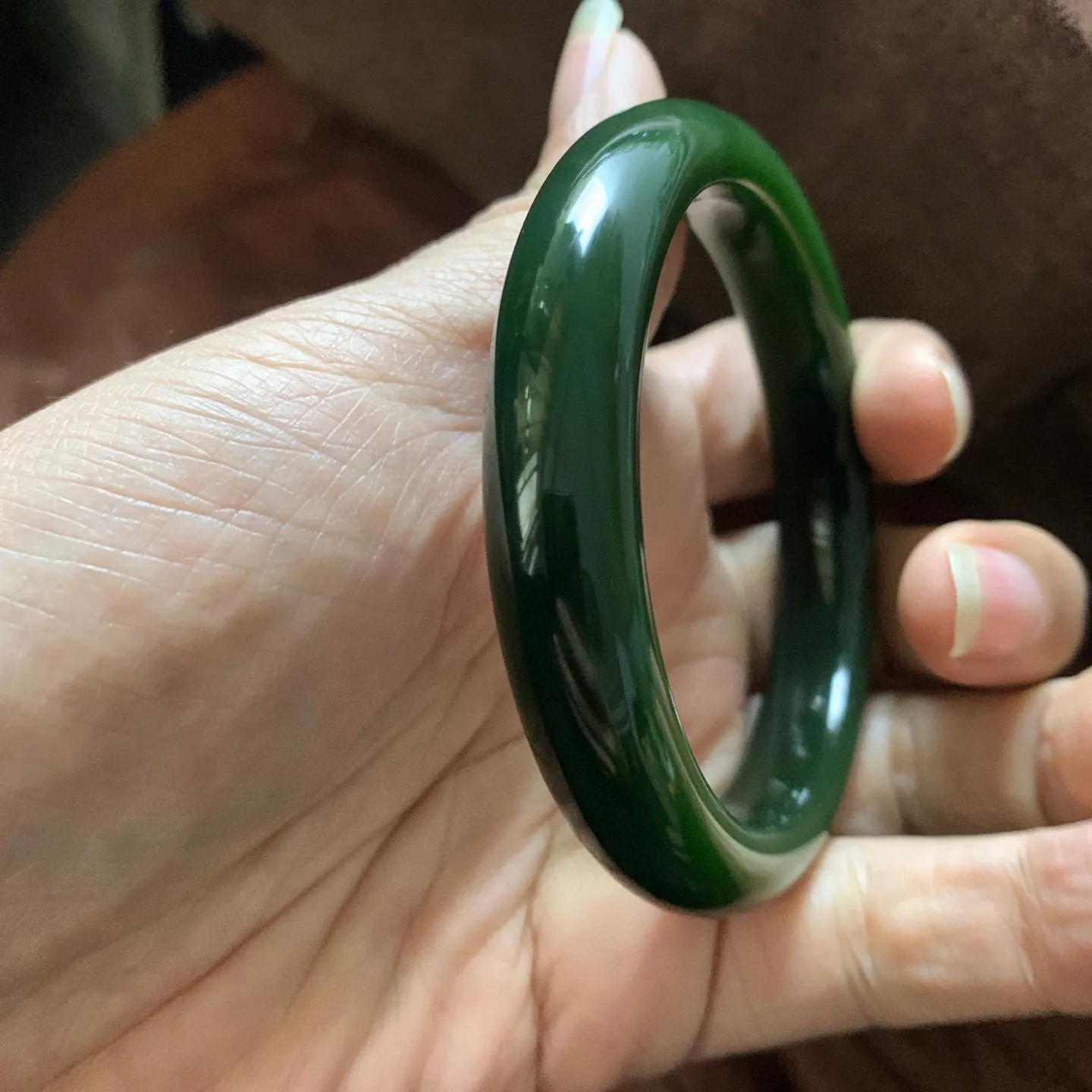 和田玉58.5圈口菠菜绿手镯，镯型古朴典雅。在诗情画意的雨巷相遇，你是我腕间的一抹风情，有你眸有深情.清风荡漾湖间静水，我愿俯身低眉，在烟波涟漪处寻