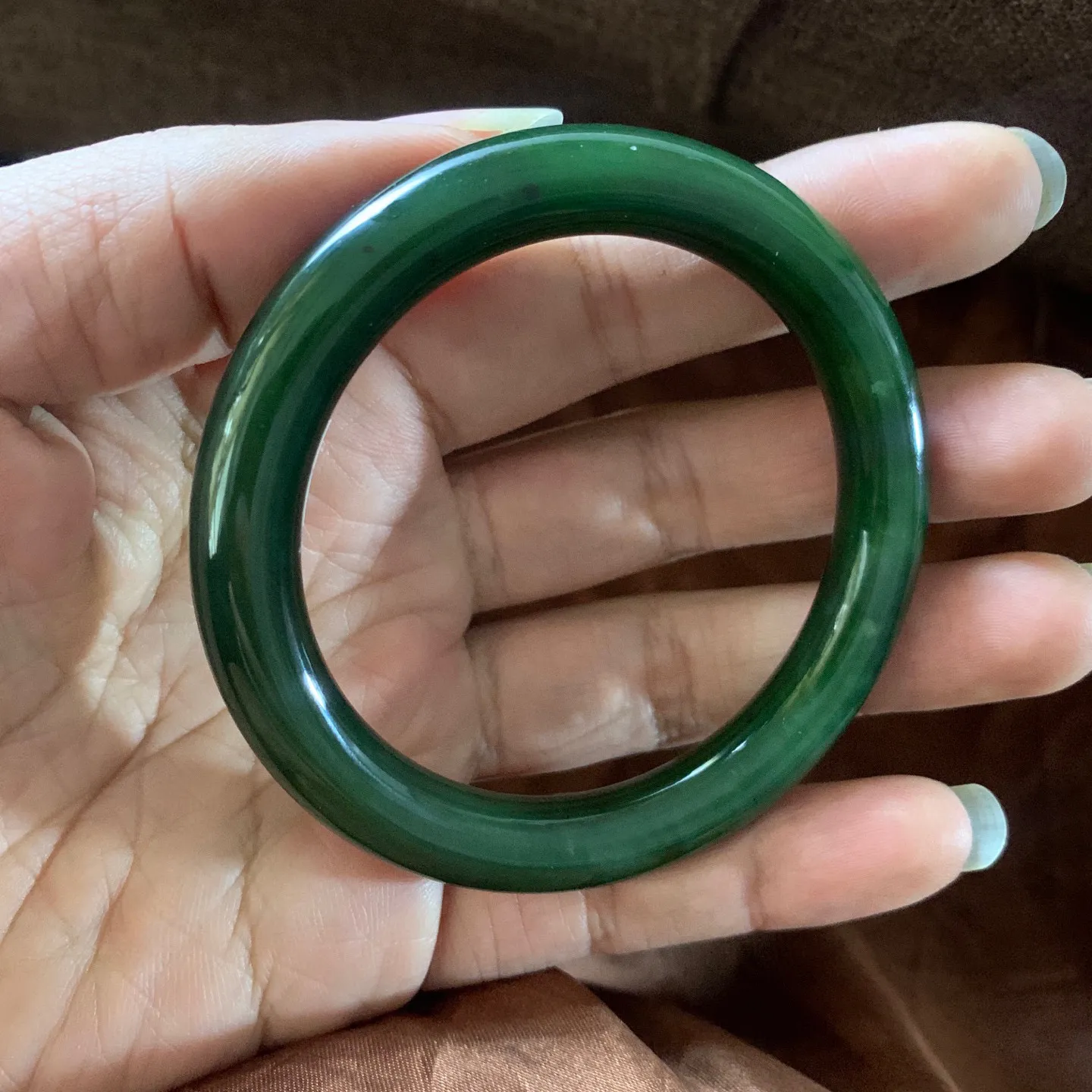 和田玉58圈口菠菜绿圆条手镯【挽间柔情】，镯型古朴典雅。在诗情画意的雨巷相遇，你是我腕间的一抹风情，有你眸有深情.清风荡漾湖间静水，我愿俯身低眉，在烟波涟漪处寻