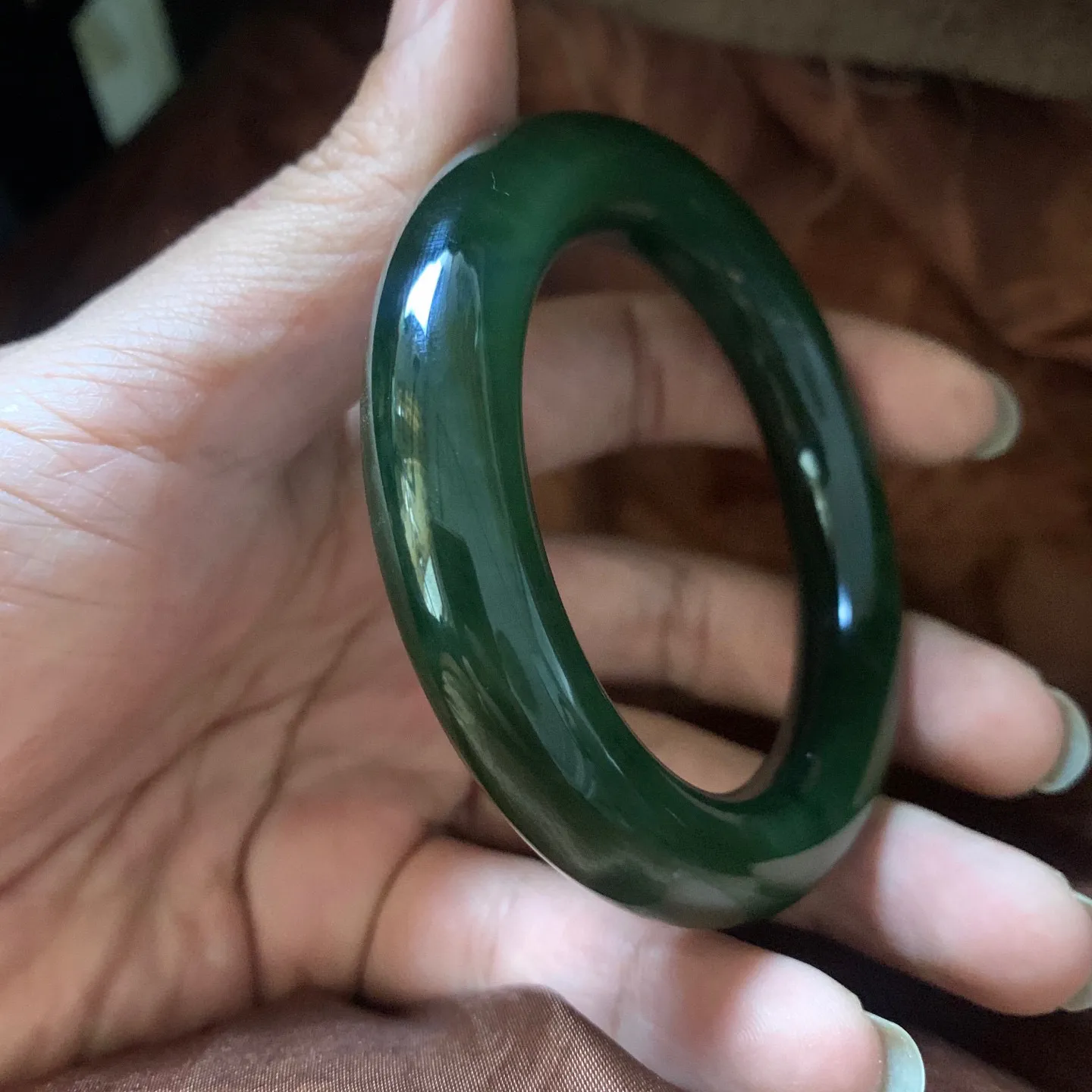 和田玉54.1圈口冰底菠菜绿圆条手镯，镯型古朴典雅。在诗情画意的雨巷相遇，你是我腕间的一抹风情，有你眸有深情.清风荡漾湖间静水，我愿俯身低眉，在烟波涟漪处寻