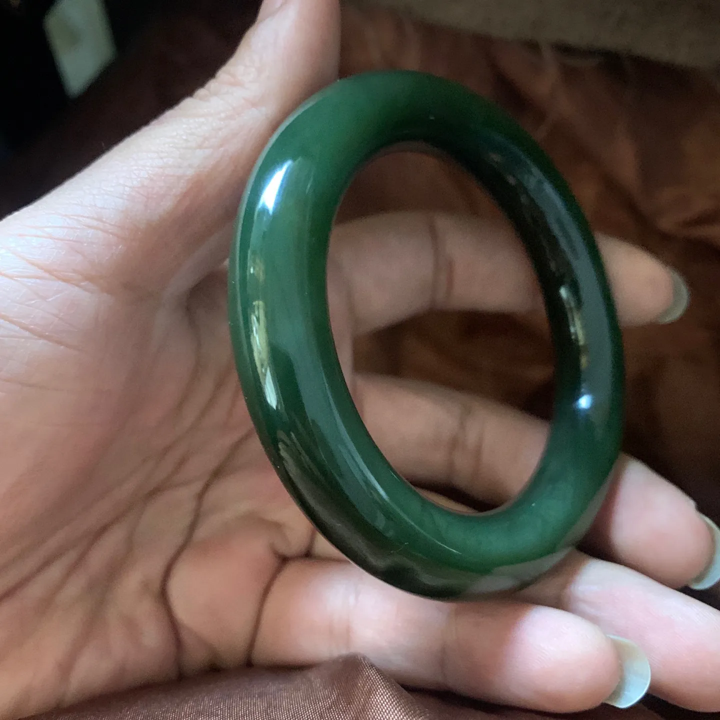 和田玉54.1圈口冰底菠菜绿圆条手镯，镯型古朴典雅。在诗情画意的雨巷相遇，你是我腕间的一抹风情，有你眸有深情.清风荡漾湖间静水，我愿俯身低眉，在烟波涟漪处寻