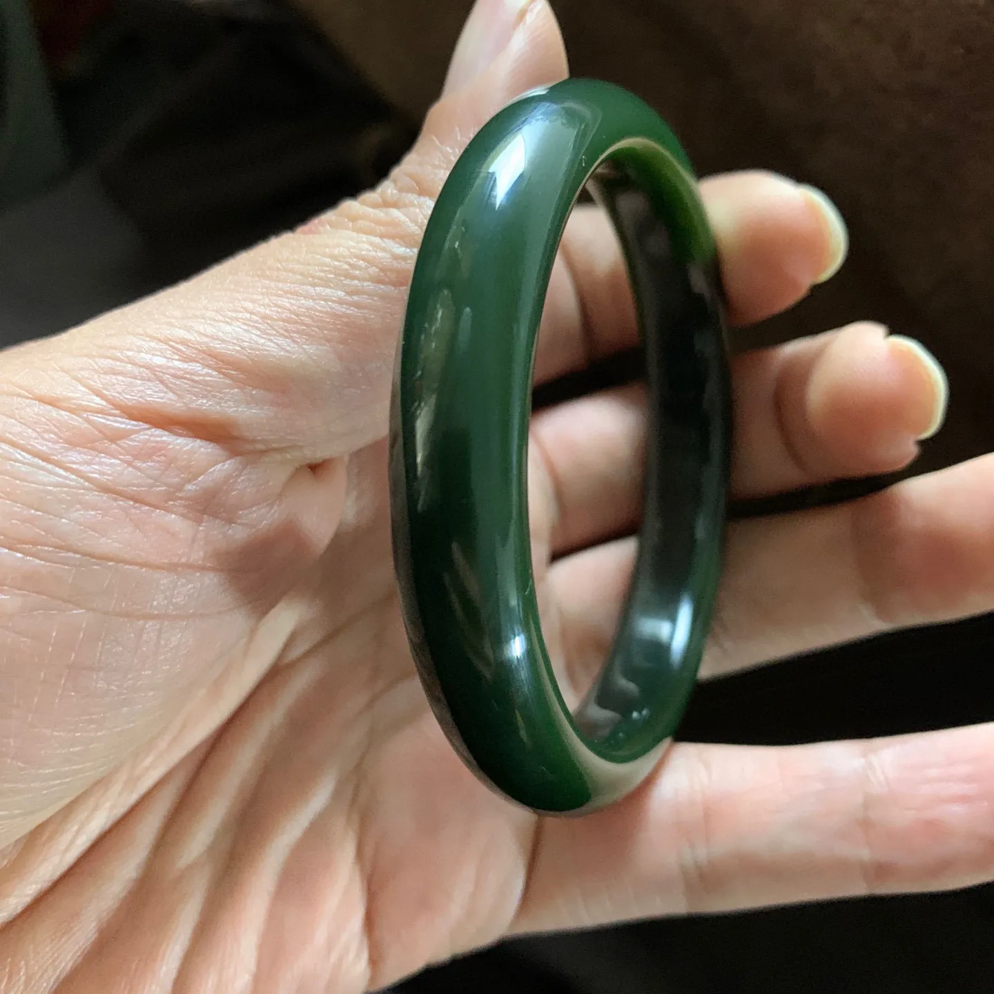 和田玉56圈口碧玉菠菜绿手镯，肉眼几乎无结构，镯型古朴典雅。在诗情画意的雨巷相遇，你是我腕间的一抹风情，有你眸有深情.清风荡漾湖间静水，我愿俯身低眉，在烟波涟漪处寻