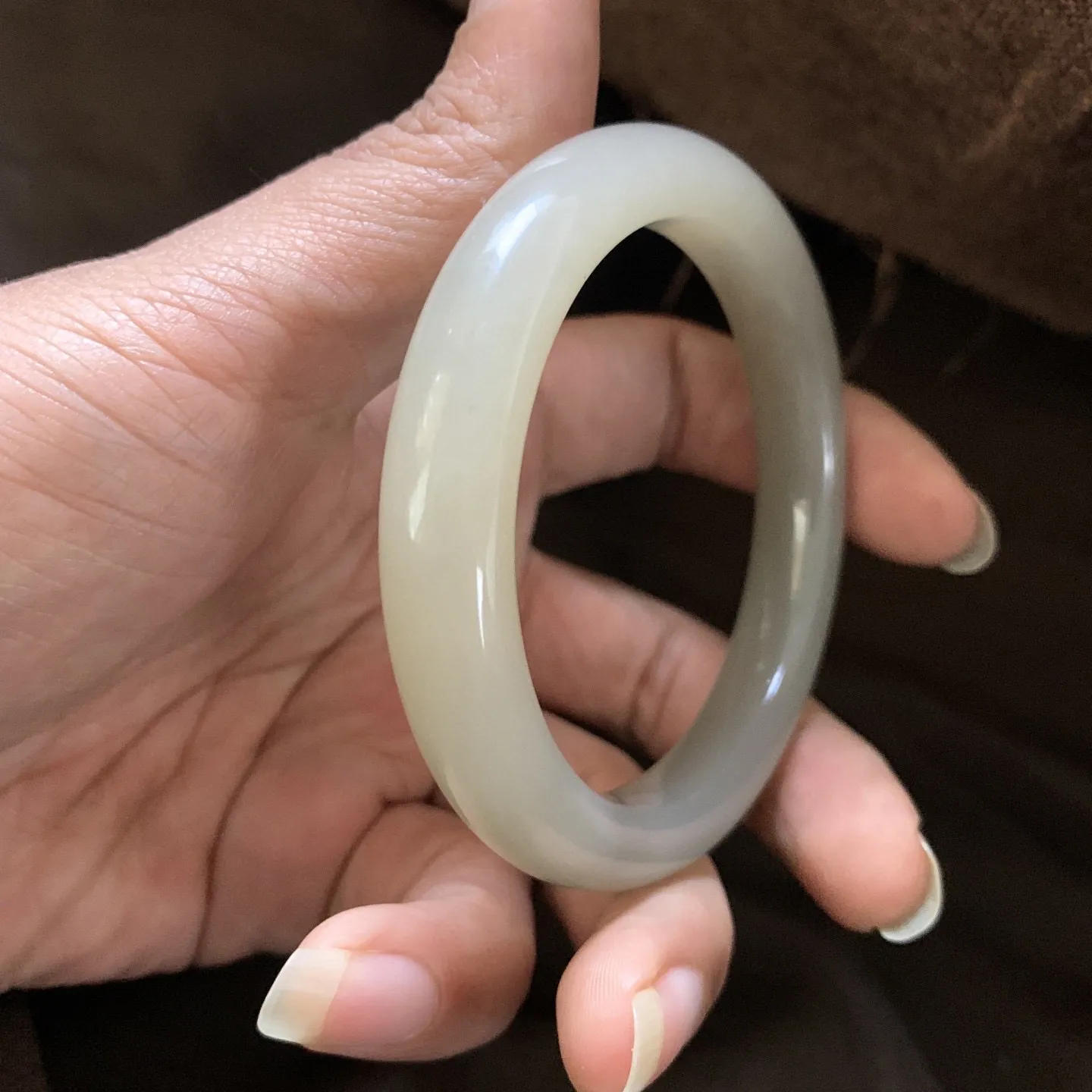 和田玉58圈口藕粉色手镯，两色藕粉，镯型古朴典雅。在诗情画意的雨巷相遇，你是我腕间的一抹风情，有你眸有深情.清风荡漾湖间静水，我愿俯身低眉，在烟波涟漪处寻