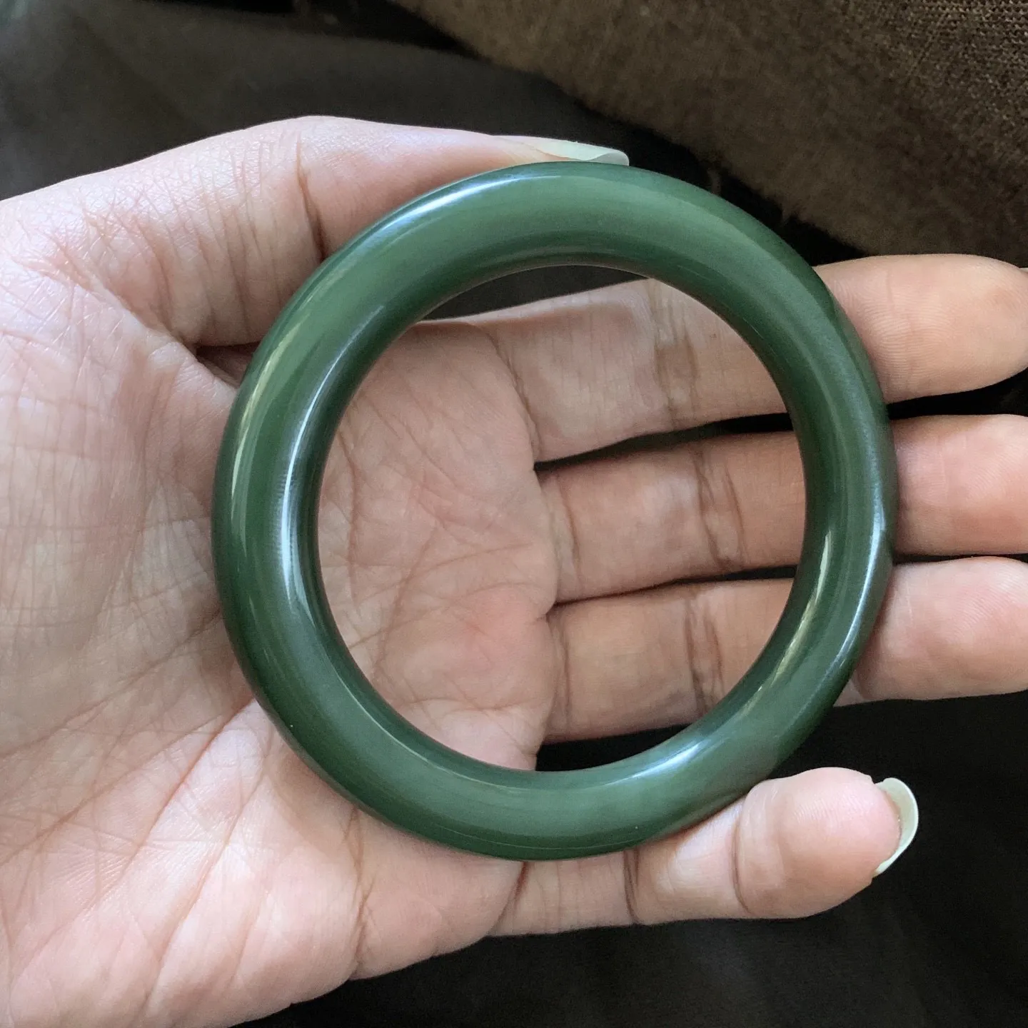 和田玉59圈口菠菜绿圆条手镯，镯型古朴典雅。在诗情画意的雨巷相遇，你是我腕间的一抹风情，有你眸有深情.清风荡漾湖间静水，我愿俯身低眉，在烟波涟漪处寻