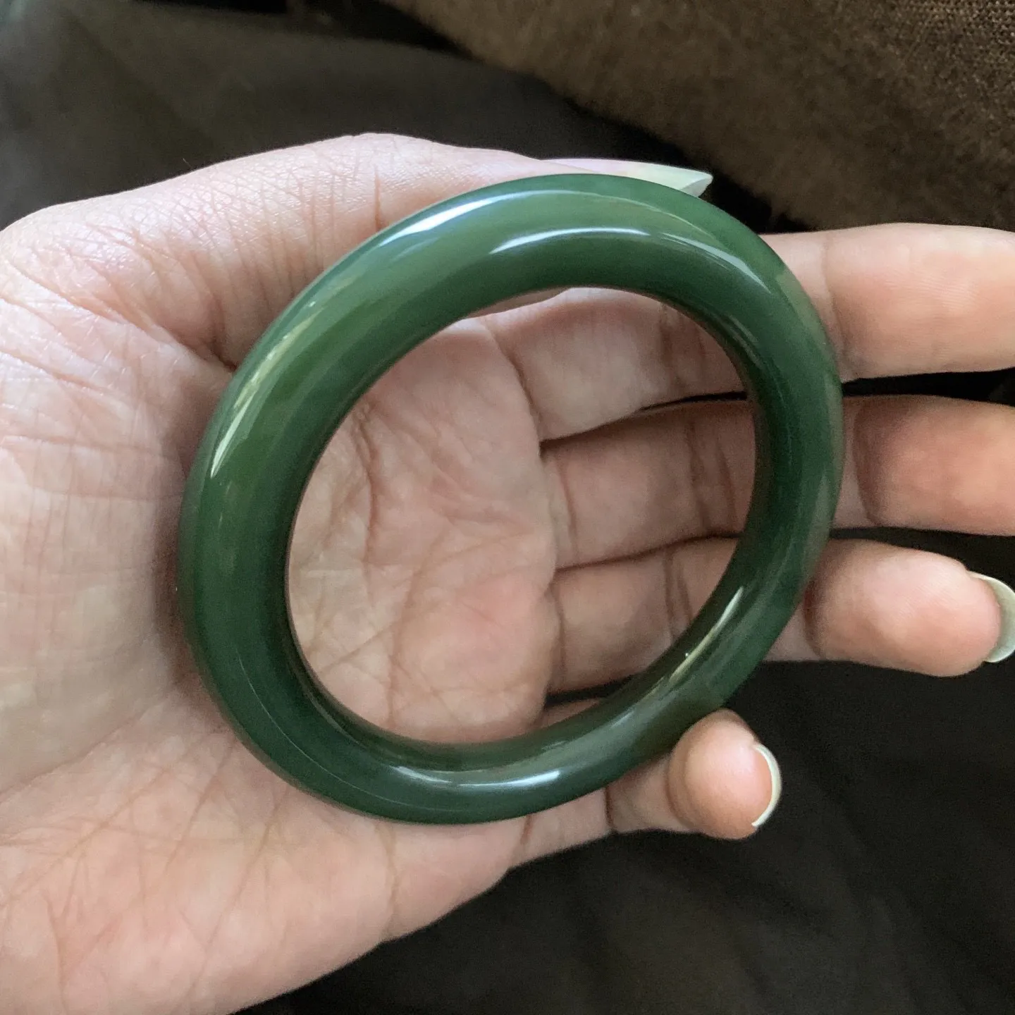 和田玉59圈口菠菜绿圆条手镯，镯型古朴典雅。在诗情画意的雨巷相遇，你是我腕间的一抹风情，有你眸有深情.清风荡漾湖间静水，我愿俯身低眉，在烟波涟漪处寻