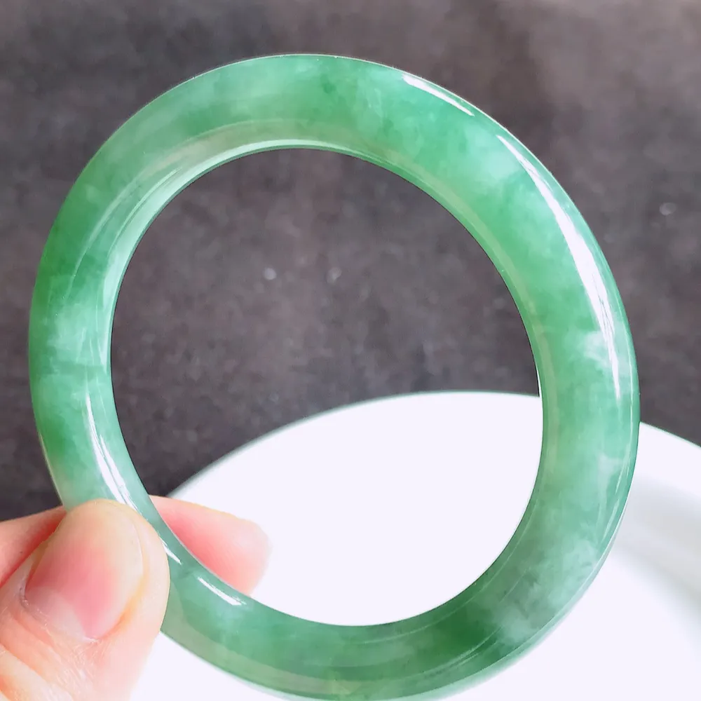 缅甸翡翠圆条手镯54mm  冰润飘花圆条翡翠手镯，玉质细腻水润，色泽清秀亮丽，飘花灵动  上手高贵典雅，W922.27  尺寸：54-9.2mm