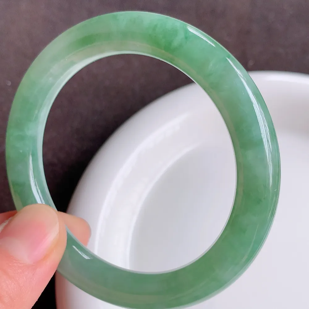 缅甸翡翠圆条手镯54mm  冰润飘花圆条翡翠手镯，玉质细腻水润，色泽清秀亮丽，飘花灵动  上手高贵典雅，W922.27  尺寸：54-9.2mm