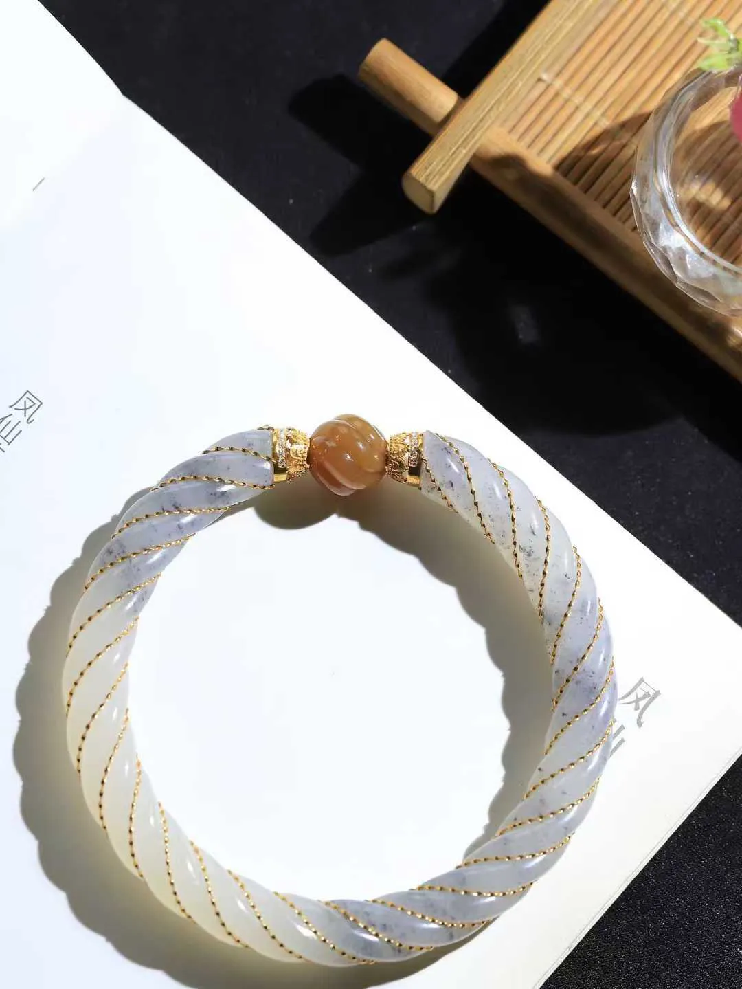 【麻花.手镯】

精品和田玉三色18k金镶嵌麻花手镯，玉质温润细腻，做工精湛，昆仑雪色凝作绕指柔，双股玉丝盘绕成圆满。纹如藤蔓相生，喻情缘坚韧交织；形似时空之环，藏天地生生不息。佩于腕间，是柔韧的智慧，亦是绵长的祝福——让每一次缠绕，都成为时光里解不开的缘分结。重37.6克   尺寸59.5-9.2-9.2mm  8910300L

​