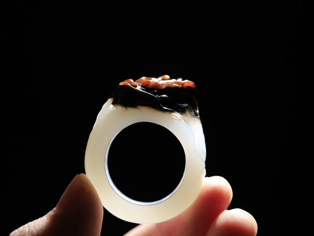 （龙行天下.扳指）

精品和田玉白玉带皮祥龙扳指，料子细腻 手感上佳、雕工精湛，精雕祥龙，龙头双目圆瞪，巨口大张，獠牙锋利， 龙是古代祥瑞之物，寓意有龙护身，
重29.3克    圈口23.4mm   尺寸18.5-15.3mm fDL-75102892