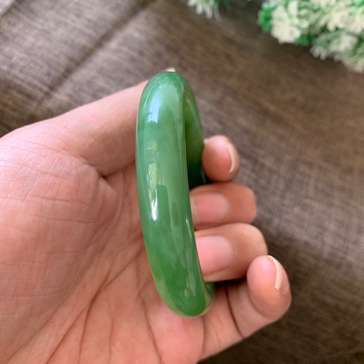 和田玉55圈口阳绿色猫眼手镯，镯型古朴典雅。在诗情画意的雨巷相遇，你是我腕间的一抹风情，有你眸有深情.清风荡漾湖间静水，我愿俯身低眉，在烟波涟漪处寻