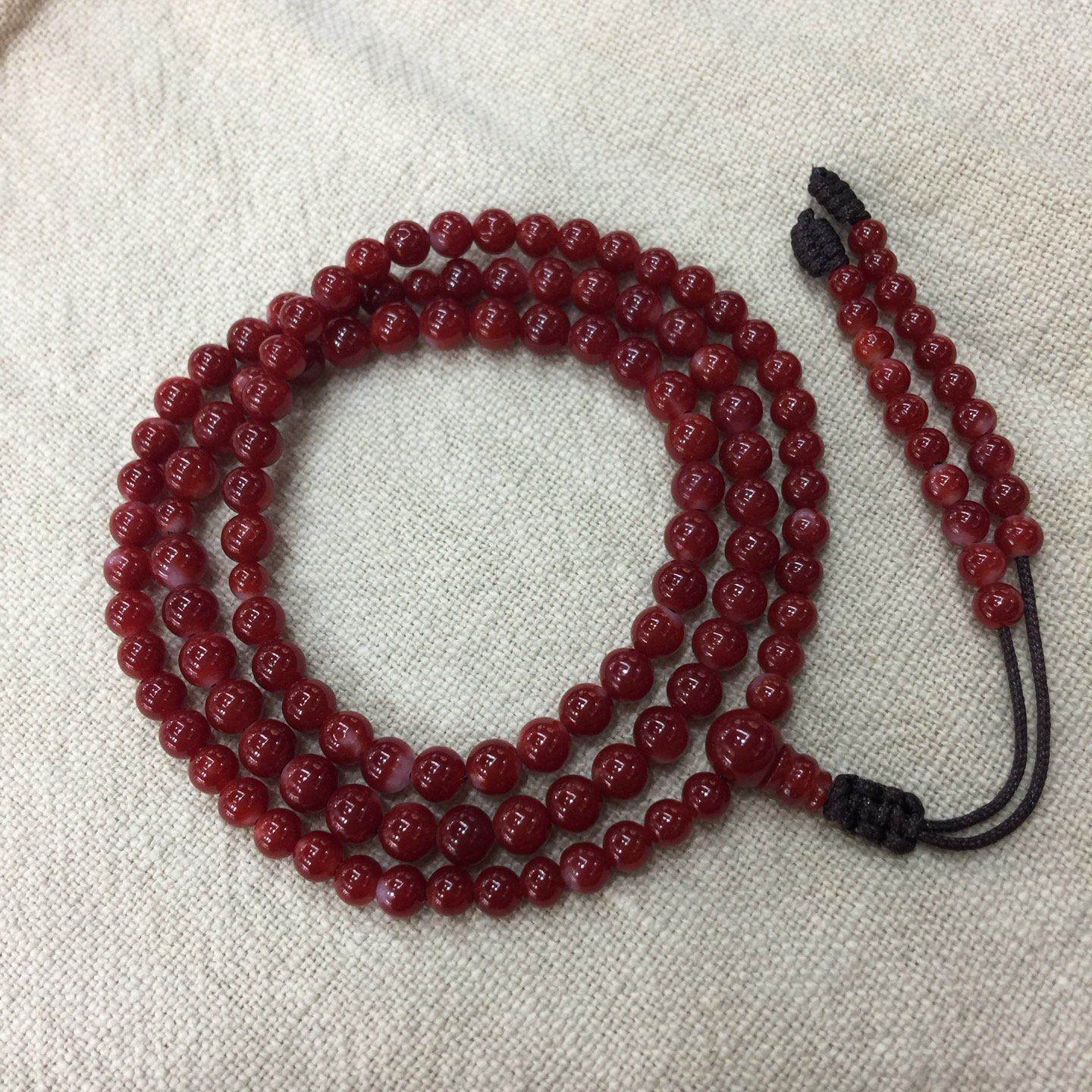 【阿卡赤血牛血红珊瑚108小5mm圆珠手链款】难得高瓷度，整条少白芯的阿卡圆珠。整条赤血牛血红颜色，珠子直径4.9-3.7mm，每颗珠子均为天然的珊瑚，珊瑚自古就为佛教珍宝，深海千年有机宝石！收藏价值高、可传承！重量13.17克！追求品质者的福音！实物漂亮！