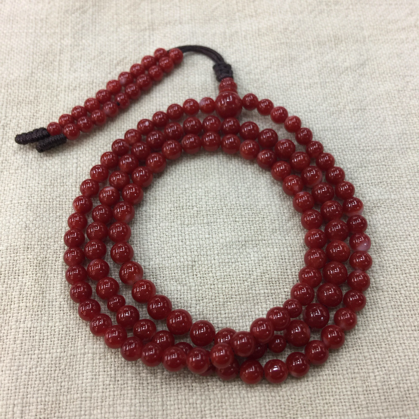 【阿卡赤血牛血红珊瑚108小5mm圆珠手链款】难得高瓷度，整条少白芯的阿卡圆珠。整条赤血牛血红颜色，珠子直径5-4mm，每颗珠子均为天然的珊瑚，珊瑚自古就为佛教珍宝，深海千年有机宝石！收藏价值高、可传承！总重13.43克！追求品质者的福音！实物漂亮！