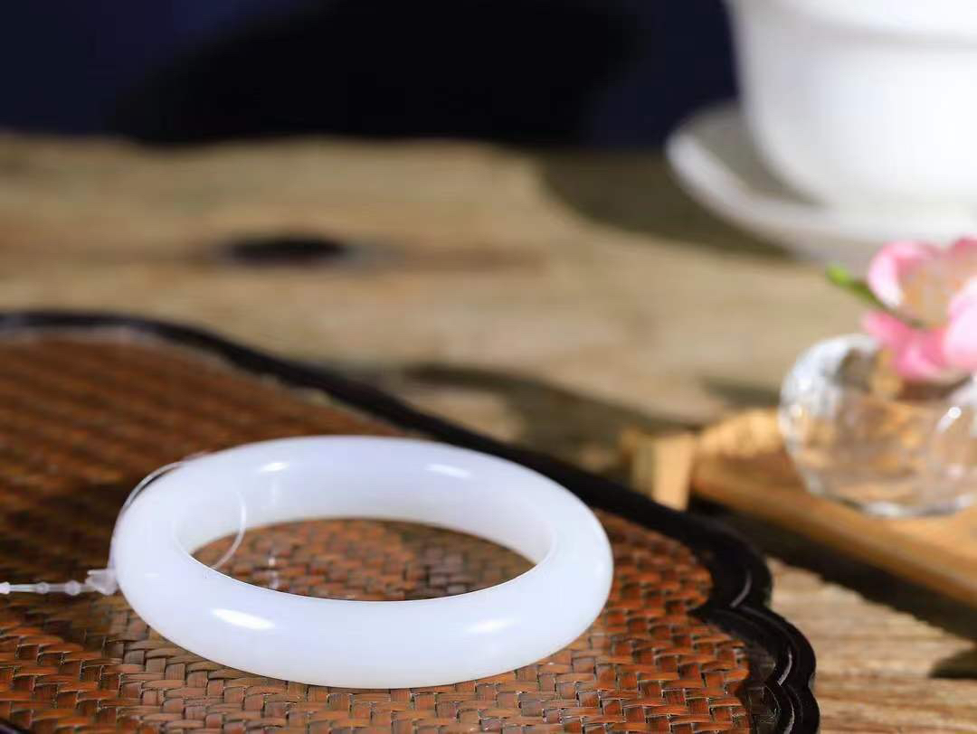 （一见倾心.手镯）

精品和田玉白玉手镯，玉质温润细腻 油性十足 手感舒适，高华雅逸，线条流畅，简约大气，美自天成，素雅高贵。佩戴于腕间，婉约之美，举手投足间透出那低调奢华。重63.6克 尺寸56-12.6-9.5mm1731930T