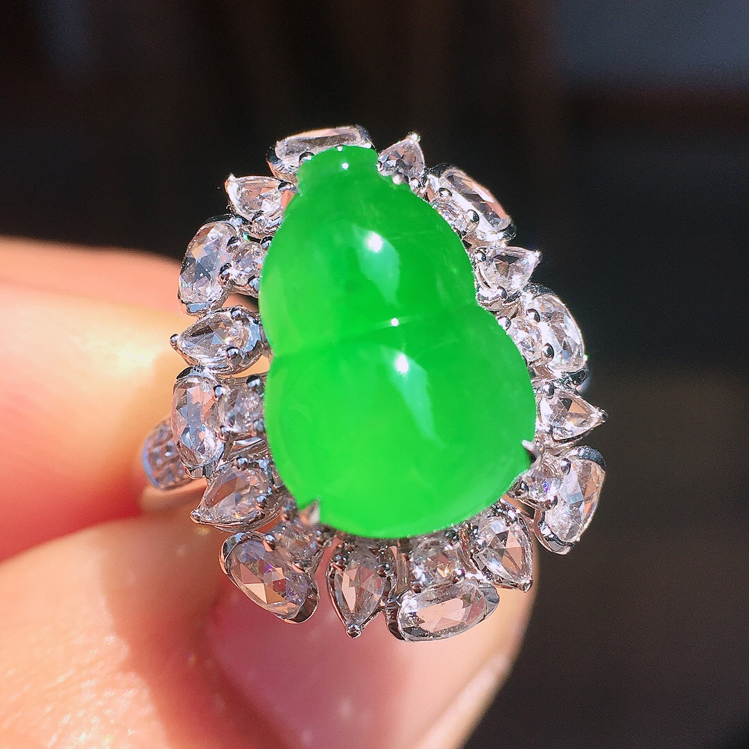 阳绿葫芦戒指，色泽均匀艳丽，玉质细腻，荧光感超
强，饱满圆润，尽显优雅气质，18k
金豪华镶嵌