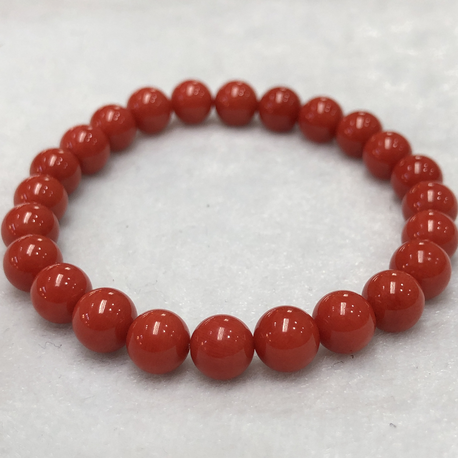 【天然深橘红珊瑚7.6mm圆珠弹力单手串】深橘红颜色，光泽柔润透亮，直径约7.6-7.2mm，重量14.22克。珊瑚本为佛教珍宝，来自深海千年生长，属于有机宝石，气场强大，材料意大利沙丁材料，稀少珍贵！每粒均为天然无添加无修补！收藏精品！传承宝贝！