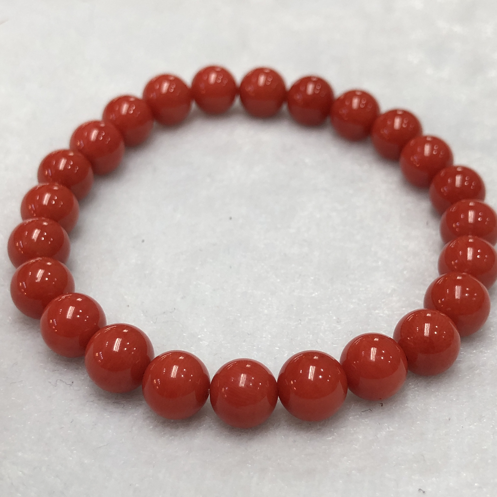 【天然深橘红珊瑚7.6mm圆珠弹力单手串】深橘红颜色，光泽柔润透亮，直径约7.6-7.2mm，重量1