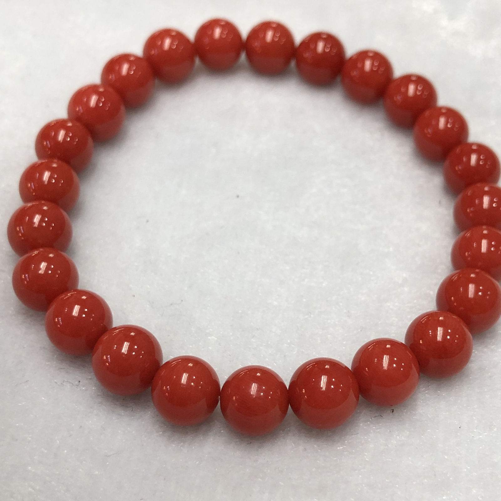 【天然深橘红珊瑚7.6mm圆珠弹力单手串】深橘红颜色，光泽柔润透亮，直径约7.6-7.2mm，重量14.22克。珊瑚本为佛教珍宝，来自深海千年生长，属于有机宝石，气场强大，材料意大利沙丁材料，稀少珍贵！每粒均为天然无添加无修补！收藏精品！传承宝贝！