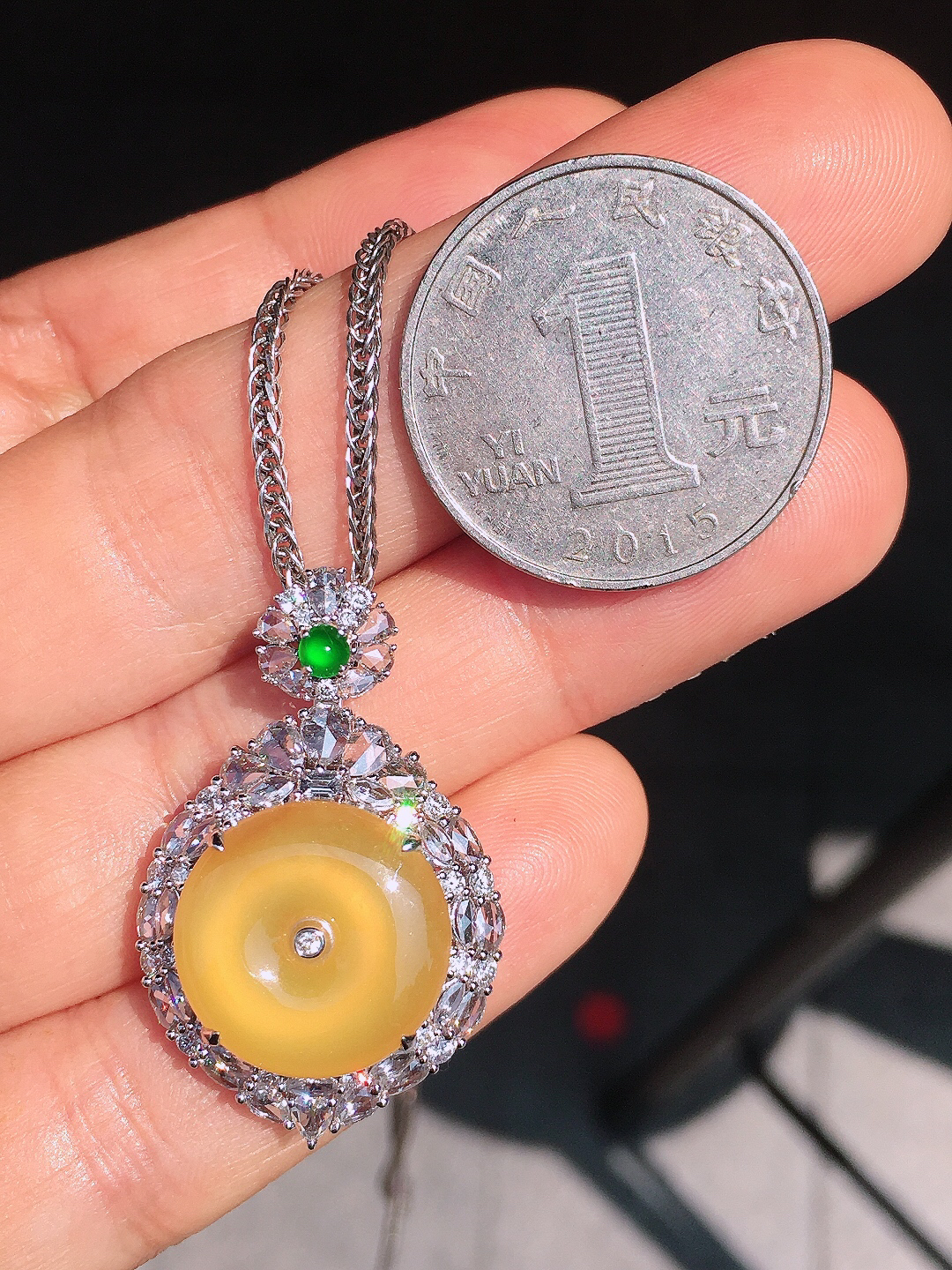 黄翡平安扣吊坠，色泽均匀艳丽，玉质细腻，荧光感超
强，饱满圆润，尽显优雅气质，18k
金豪华镶嵌