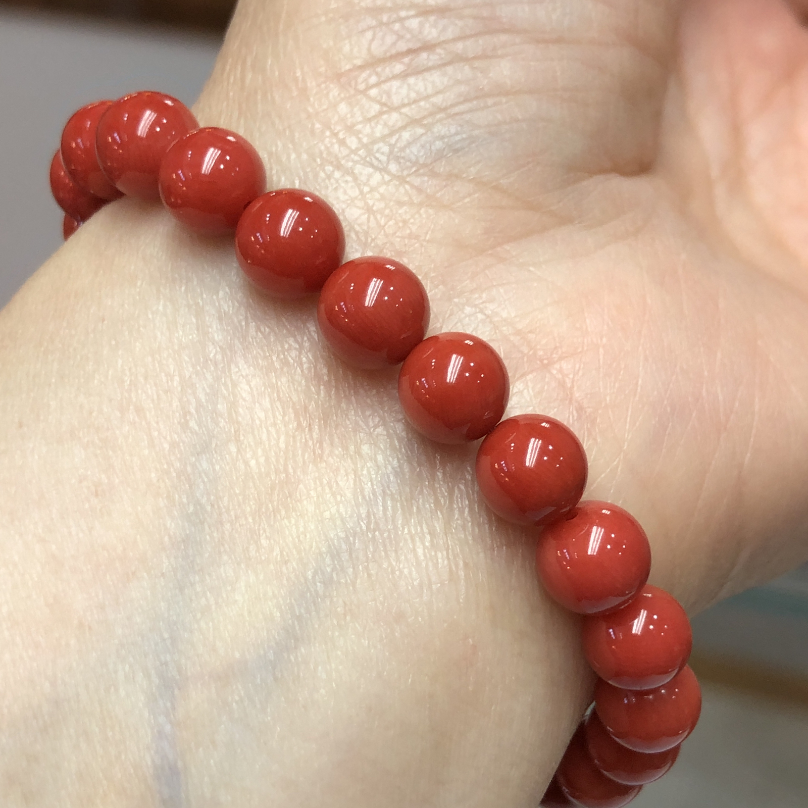 【天然深橘红珊瑚7.6mm圆珠弹力单手串】深橘红颜色，光泽柔润透亮，直径约7.6-7.2mm，重量14.22克。珊瑚本为佛教珍宝，来自深海千年生长，属于有机宝石，气场强大，材料意大利沙丁材料，稀少珍贵！每粒均为天然无添加无修补！收藏精品！传承宝贝！