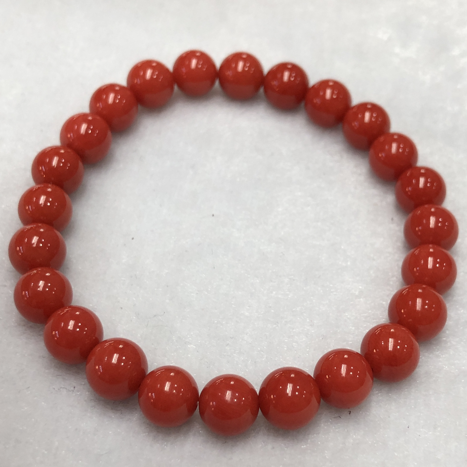 【天然深橘红珊瑚7.6mm圆珠弹力单手串】深橘红颜色，光泽柔润透亮，直径约7.6-7.2mm，重量14.22克。珊瑚本为佛教珍宝，来自深海千年生长，属于有机宝石，气场强大，材料意大利沙丁材料，稀少珍贵！每粒均为天然无添加无修补！收藏精品！传承宝贝！