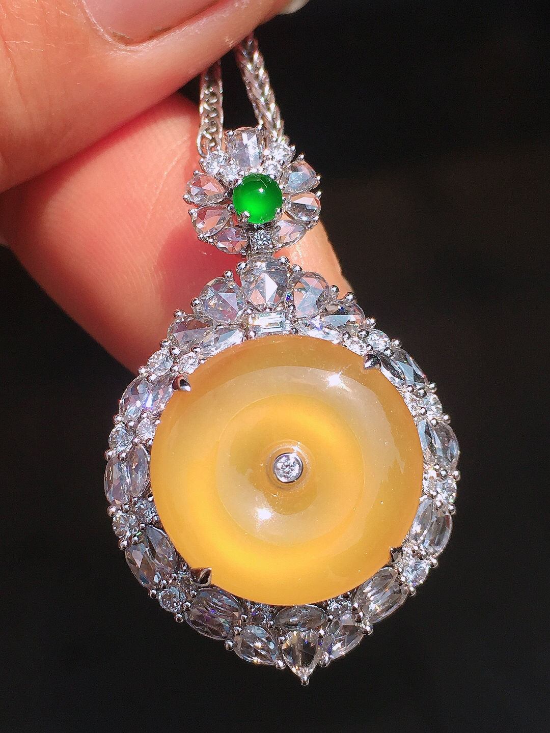 黄翡平安扣吊坠，色泽均匀艳丽，玉质细腻，荧光感超
强，饱满圆润，尽显优雅气质，18k
金豪华镶嵌