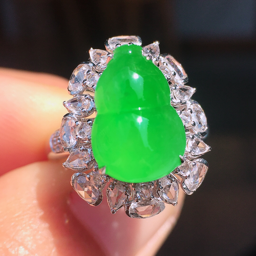 阳绿葫芦戒指，色泽均匀艳丽，玉质细腻，荧光感超
强，饱满圆润，尽显优雅气质，18k
金豪华镶嵌