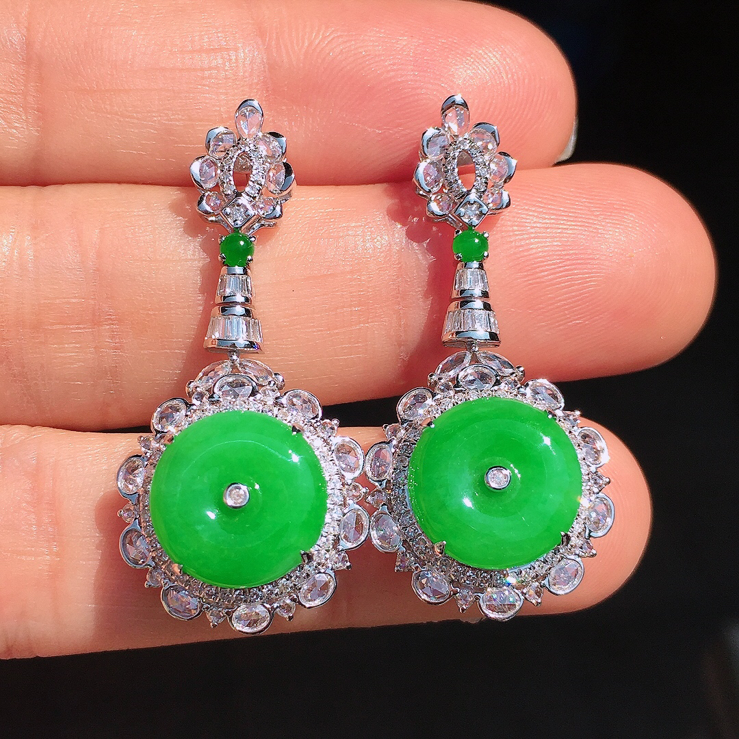 阳绿平安扣耳坠，色泽均匀艳丽，玉质细腻，荧光感超
强，饱满圆润，尽显优雅气质，18k
金豪华镶嵌