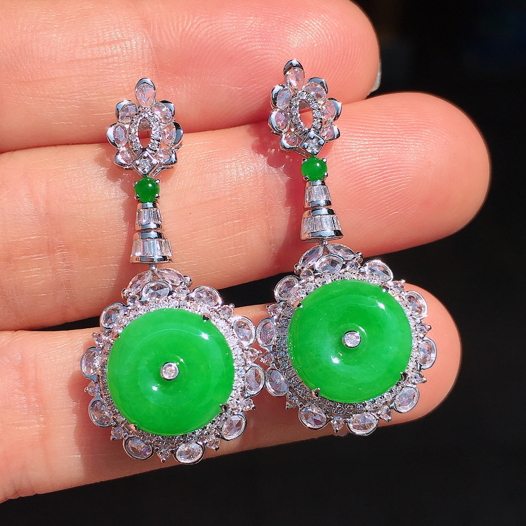 阳绿平安扣耳坠，色泽均匀艳丽，玉质细腻，荧光感超
强，饱满圆润，尽显优雅气质，18k
金豪华镶嵌