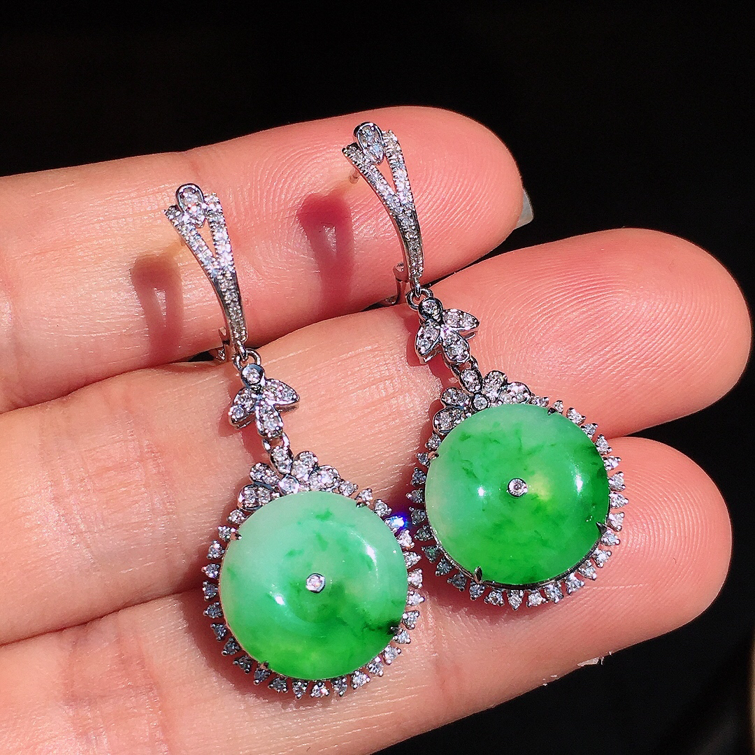 阳绿平安扣耳坠，色泽艳丽，玉质细腻，荧光感超
强，饱满圆润，尽显优雅气质，18k
金豪华镶嵌