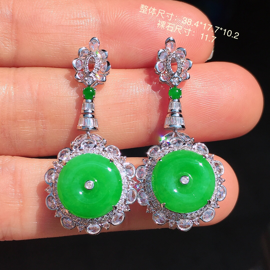 阳绿平安扣耳坠，色泽均匀艳丽，玉质细腻，荧光感超
强，饱满圆润，尽显优雅气质，18k
金豪华镶嵌