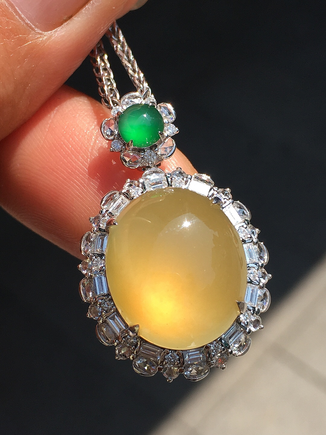 黄翡蛋面吊坠，色泽均匀艳丽，玉质细腻，荧光感超
强，饱满圆润，尽显优雅气质，18k
金豪华镶嵌