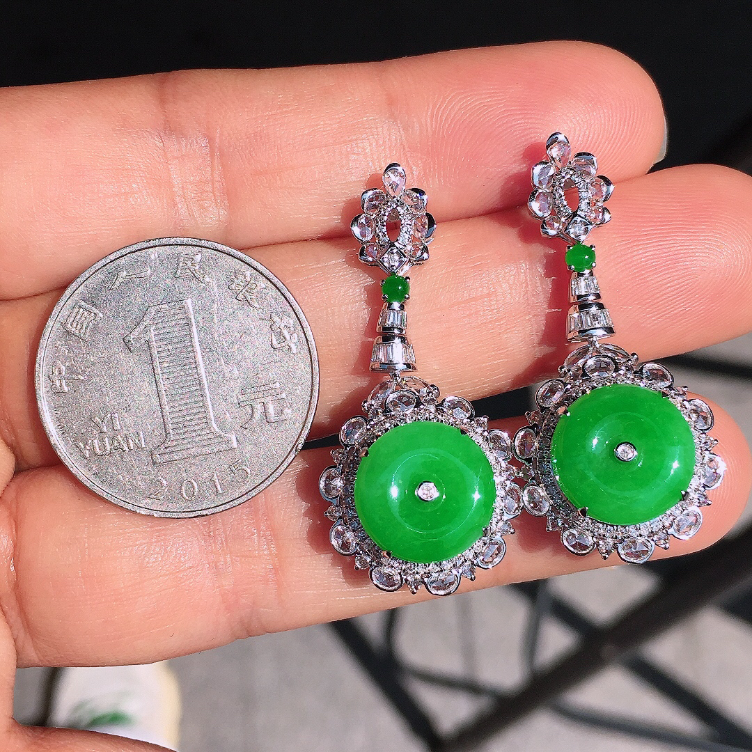 阳绿平安扣耳坠，色泽均匀艳丽，玉质细腻，荧光感超
强，饱满圆润，尽显优雅气质，18k
金豪华镶嵌