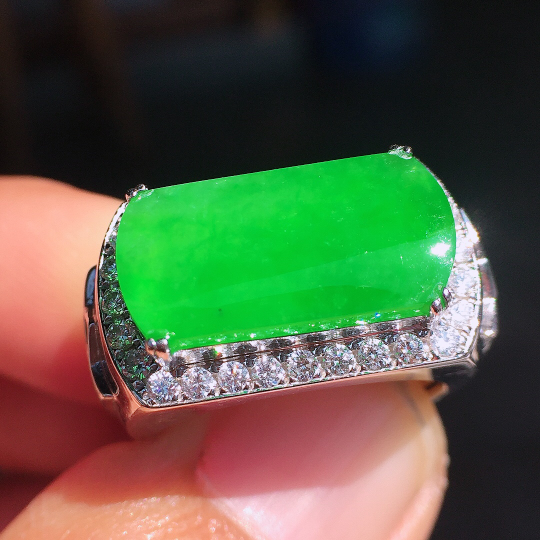 阳绿马鞍戒指，色泽均匀艳丽，玉质细腻，荧光感超
强，饱满圆润，尽显优雅气质，18k
金豪华镶嵌