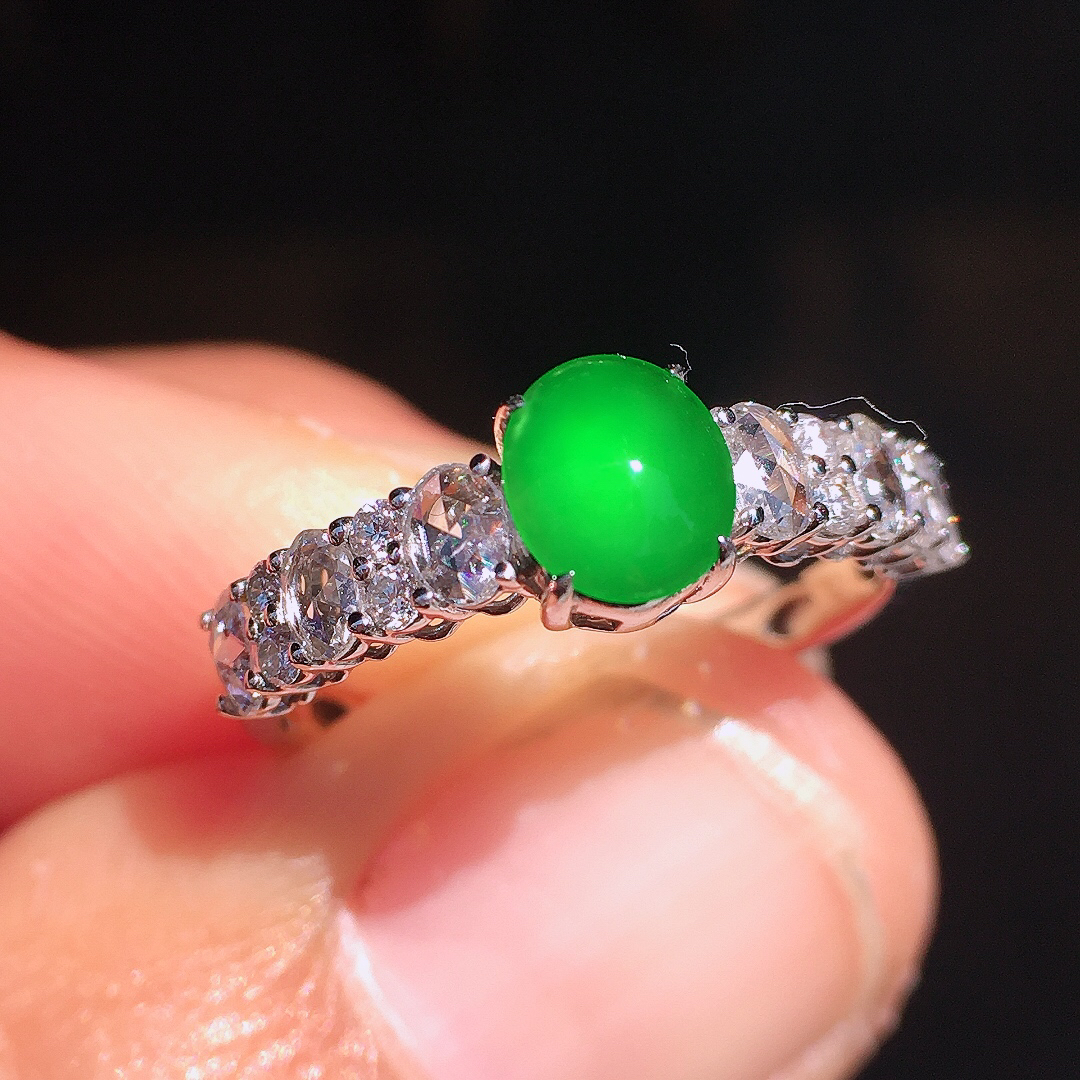 阳绿蛋面戒指，色泽均匀艳丽，玉质细腻，荧光感超
强，饱满圆润，尽显优雅气质，18k
金豪华镶嵌