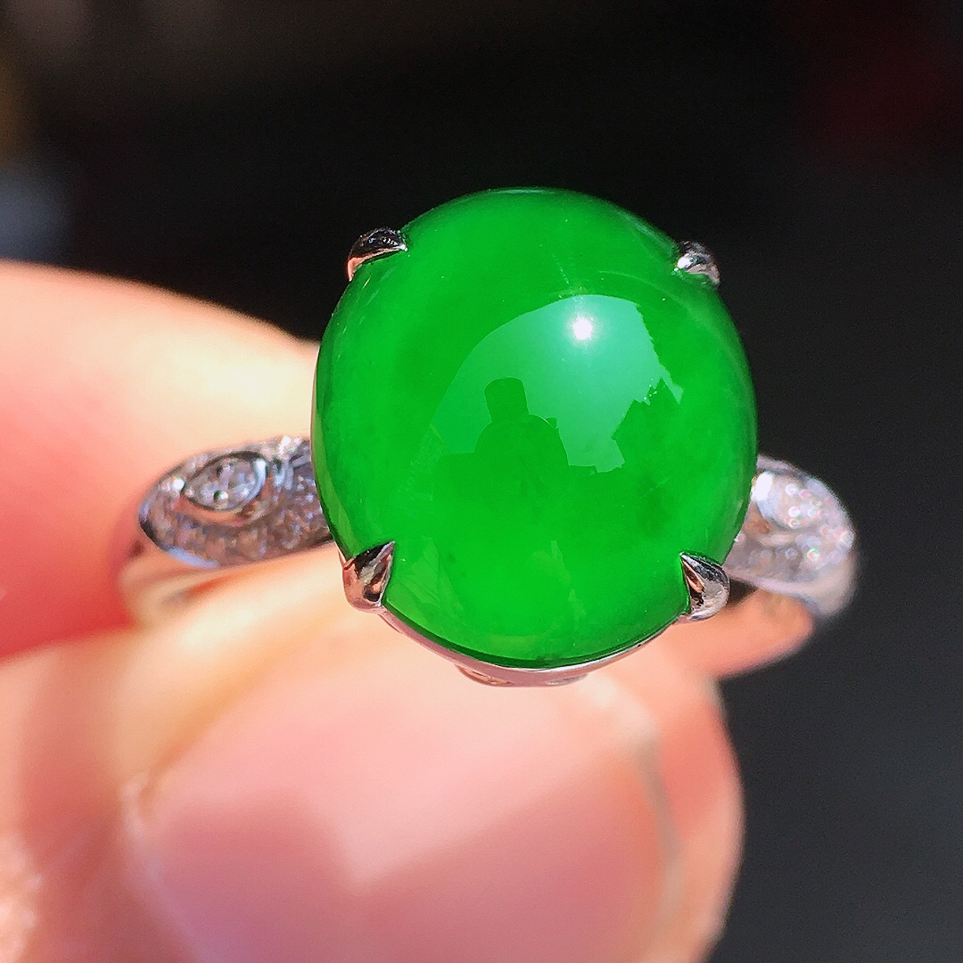 阳绿蛋面戒指，色泽均匀艳丽，玉质细腻，荧光感超
强，饱满圆润，尽显优雅气质，18k
金豪华镶嵌