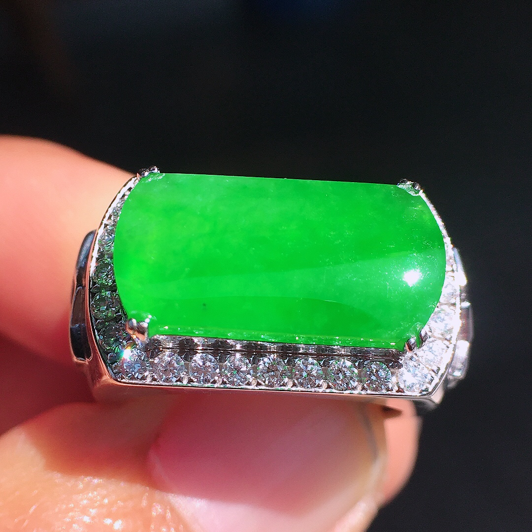 阳绿马鞍戒指，色泽均匀艳丽，玉质细腻，荧光感超
强，饱满圆润，尽显优雅气质，18k
金豪华镶嵌